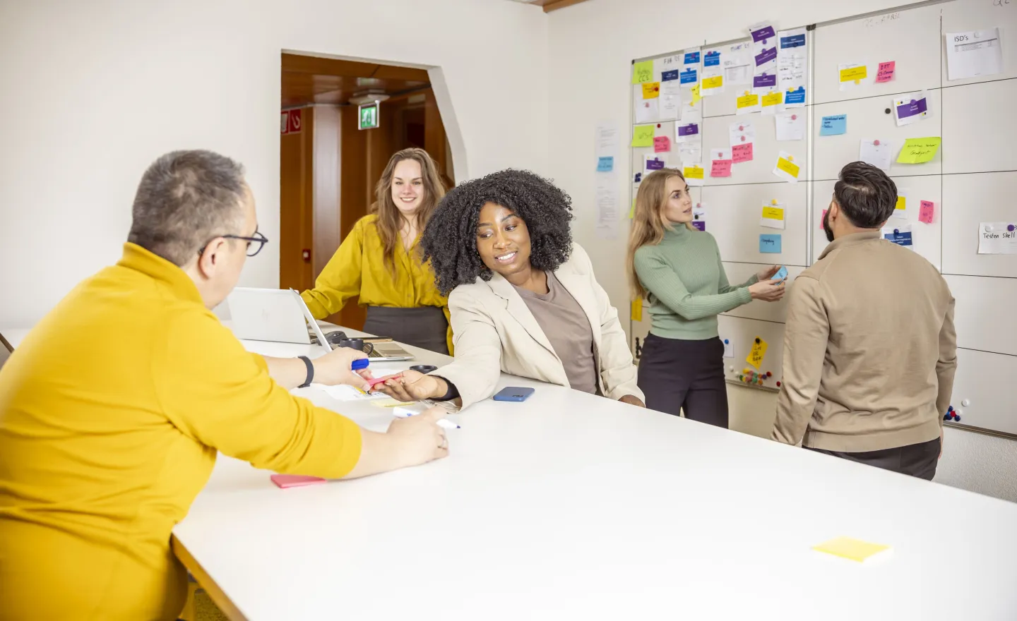 Groep collega's in een kantooromgeving die werken met post-its.
